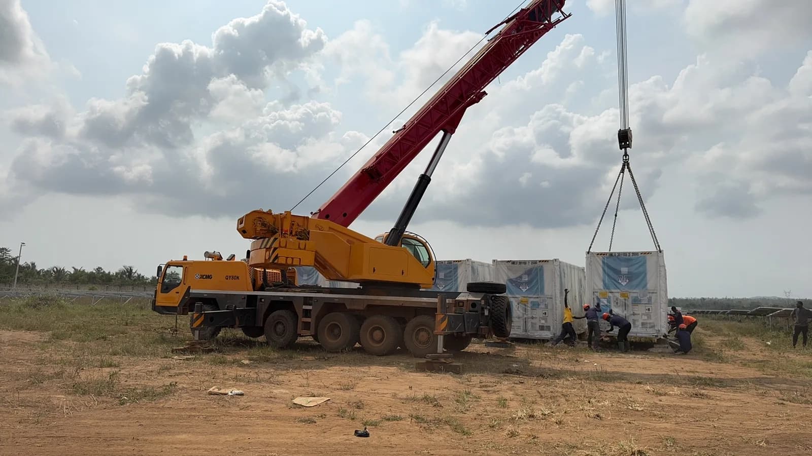 Crane lifting packaged electrical equipment on a renewable energy project site